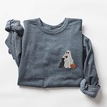 Dark Heather crewneck sweatshirt laid flat on a white background, embroidered with a small ghost lab mom sipping red wine with a black lab sitting against her and a jack-o'-lantern, on the left chest