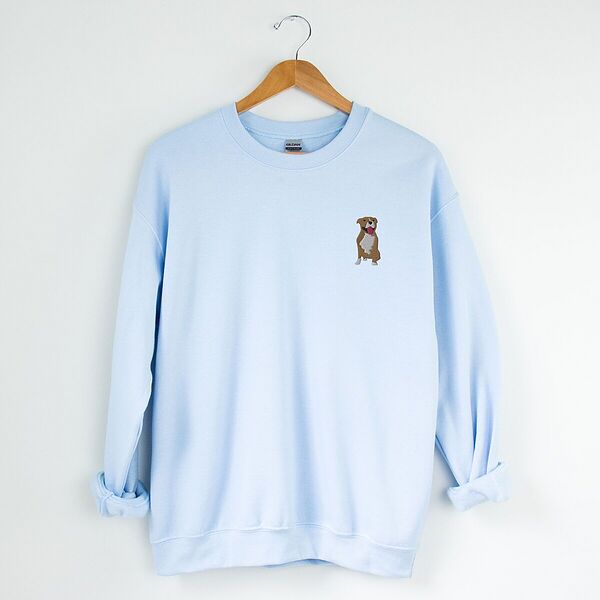 Light Blue crewneck sweatshirt on a hanger, embroidered with a small fawn and white pit bull sitting with its pink tongue out on the left chest