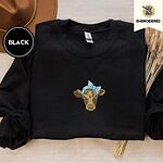 Black crewneck sweatshirt with a brown felt hat and dried bunny tail grass, embroidered with a brown calf head wearing a light blue bandana tied in a bow