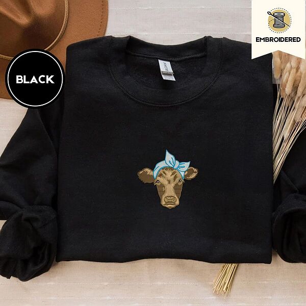 Black crewneck sweatshirt with a brown felt hat and dried bunny tail grass, embroidered with a brown calf head wearing a light blue bandana tied in a bow
