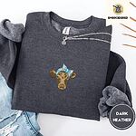 Dark Heather crewneck sweatshirt folded with ripped jeans and a silver chain necklace, embroidered with a brown calf head wearing a light blue bandana tied in a bow