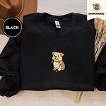 Black crewneck sweatshirt with a brown felt hat and dried bunny tail grass, embroidered with a fawn and cream English bulldog puppy in a red collar chewing a string of Christmas lights