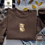 Dark Chocolate crewneck sweatshirt on a plaid flannel shirt with yellow autumn leaves and denim shorts, embroidered with a fawn and cream English bulldog puppy in a red collar chewing a string of Christmas lights