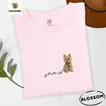Blossom Comfort Colors T-shirt embroidered with a wheaten Cairn terrier puppy in a red collar chewing the plug of a string of Christmas lights