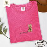 Crunchberry Comfort Colors T-shirt embroidered with a wheaten Cairn terrier puppy in a red collar chewing the plug of a string of Christmas lights