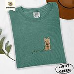 Light Green Comfort Colors T-shirt embroidered with a wheaten Cairn terrier puppy in a red collar chewing the plug of a string of Christmas lights