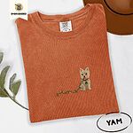 Yam Comfort Colors T-shirt embroidered with a wheaten Cairn terrier puppy in a red collar chewing the plug of a string of Christmas lights
