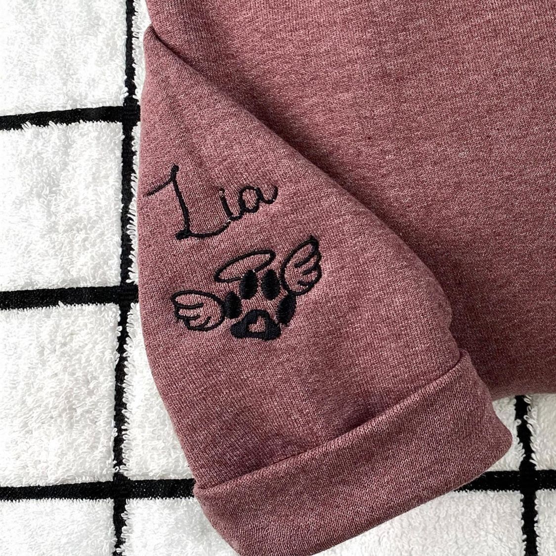 Cat Memorial Sleeve – Name and Angel Paw Sleeve embroidery of the name Lia in black script above an angel-wing paw print with a halo