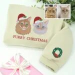 Sand Christmas sweatshirt with two embroidered cats in Santa hats with holly, Furry Christmas text and a wreath on the sleeve