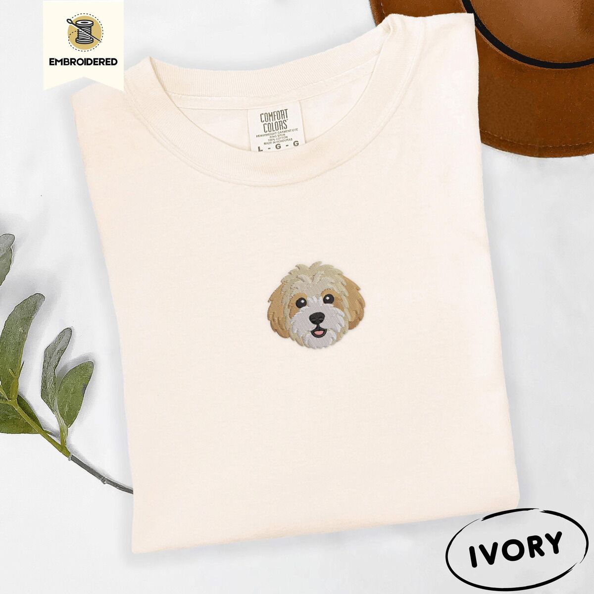 Cavachon Shirt – Ivory Ivory Comfort Colors T-shirt embroidered with a mini Cavachon face in cream and apricot with a white muzzle