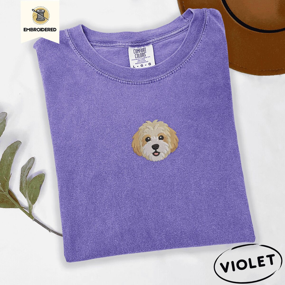 Cavachon Shirt – Violet Violet Comfort Colors T-shirt embroidered with a mini Cavachon face in cream and apricot with a white muzzle
