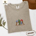 Khaki Comfort Colors T-shirt embroidered with two Blenheim Cavalier King Charles Spaniels in knit beanies beside a little lit Christmas tree