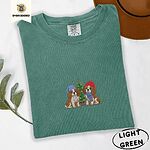 Light Green Comfort Colors T-shirt embroidered with two Blenheim Cavalier King Charles Spaniels in knit beanies beside a little lit Christmas tree