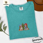 Seafoam Comfort Colors T-shirt embroidered with two Blenheim Cavalier King Charles Spaniels in knit beanies beside a little lit Christmas tree