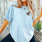 Woman in a loose Chambray T-shirt with a brown Labrador silhouette holding a flag on the left chest