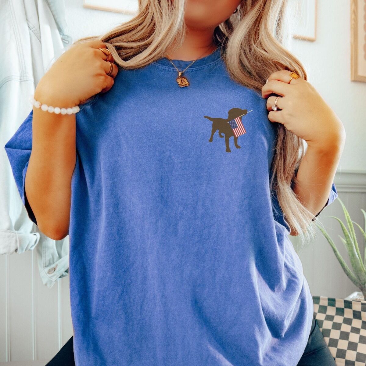 Chocolate Lab American Flag Shirt – Flo Blue Woman in a Flo Blue T-shirt with a small chocolate lab and American flag embroidered on the left chest