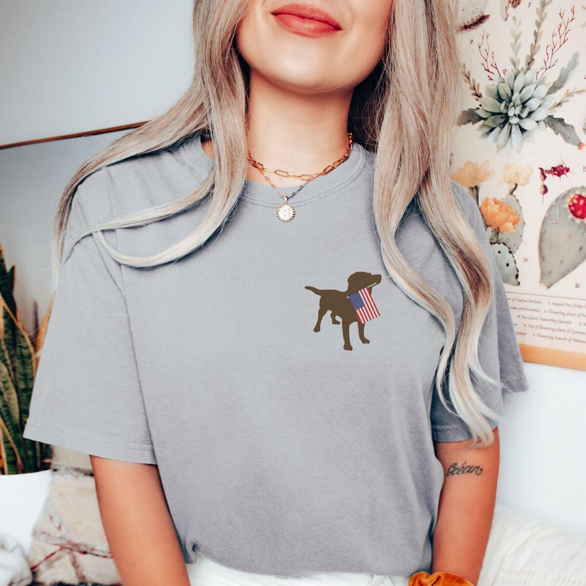 Chocolate Lab American Flag Shirt - Grey Woman in a Grey T-shirt with a chocolate lab silhouette holding a small USA flag on the left chest
