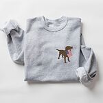 Sport Grey crewneck sweatshirt laid flat with rolled sleeves, a chocolate lab silhouette with an American flag on the left chest