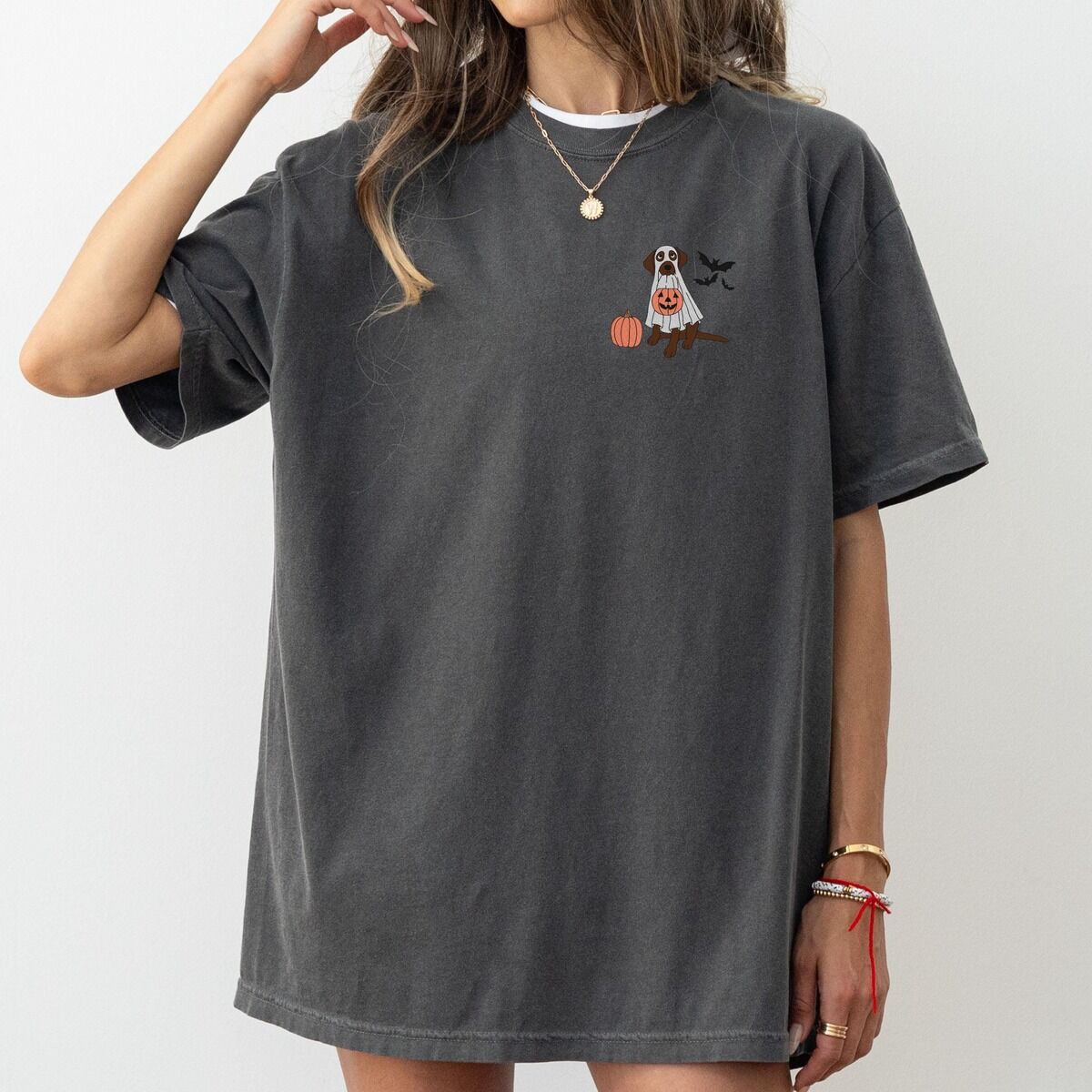 Chocolate Lab Ghost Shirt – Pepper Woman in an oversized Pepper T-shirt embroidered with a small chocolate lab in a ghost sheet on the left chest