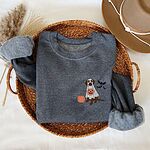 Dark Heather crewneck sweatshirt folded in a wicker basket, embroidered with a chocolate Labrador trick-or-treating in a ghost sheet