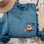 Indigo Blue crewneck sweatshirt laid flat with a felt hat and dried pampas grass, embroidered with a chocolate lab in a white ghost costume and three bats