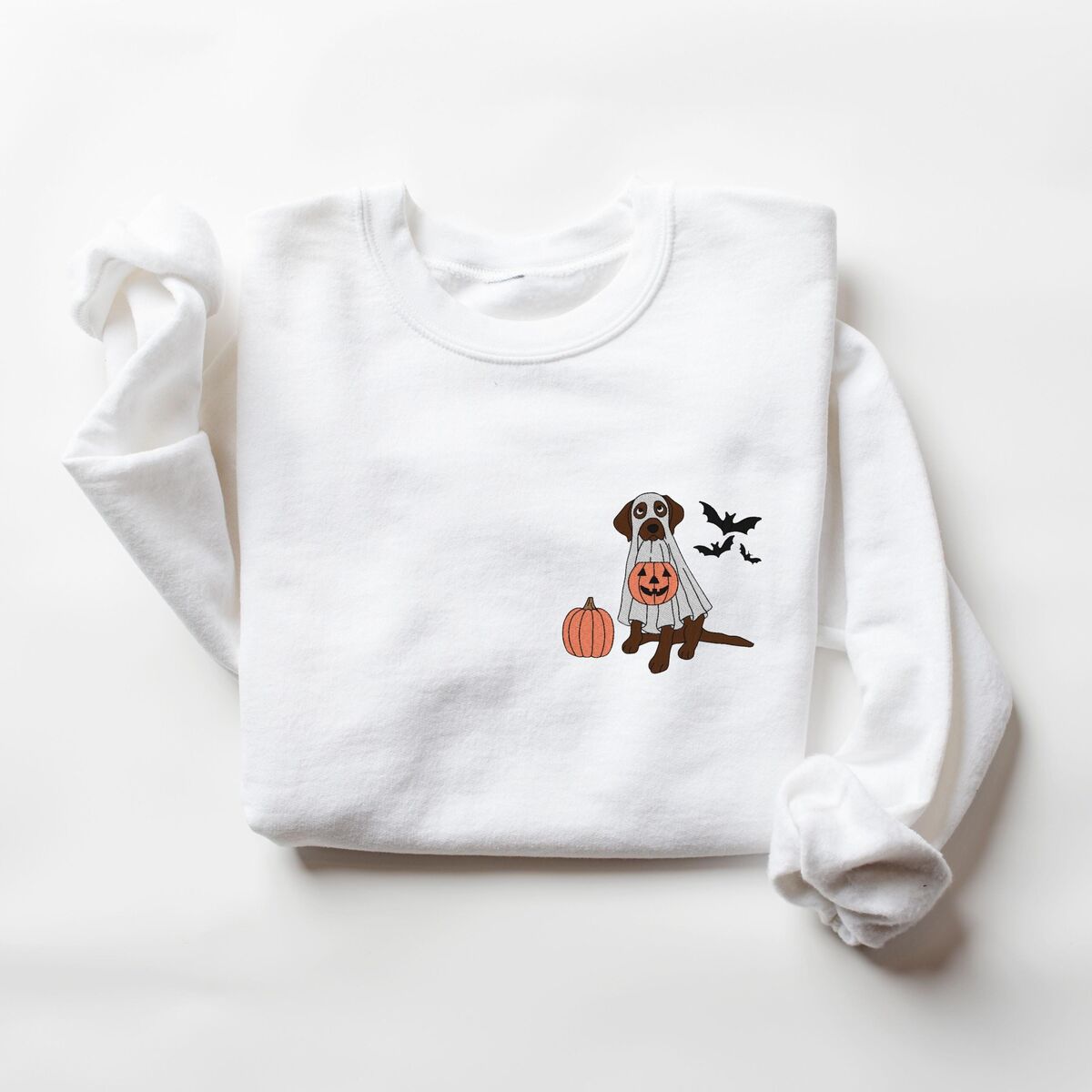 Chocolate Lab Ghost Sweatshirt - White White crewneck sweatshirt laid flat on a white background, embroidered with a chocolate lab in a ghost costume beside a pumpkin and three bats