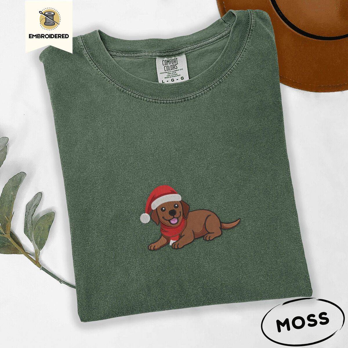 Chocolate Lab Santa Hat Shirt – Moss Moss Comfort Colors T-shirt embroidered with a chocolate Labrador puppy lying down in a red Santa hat and a red knit scarf