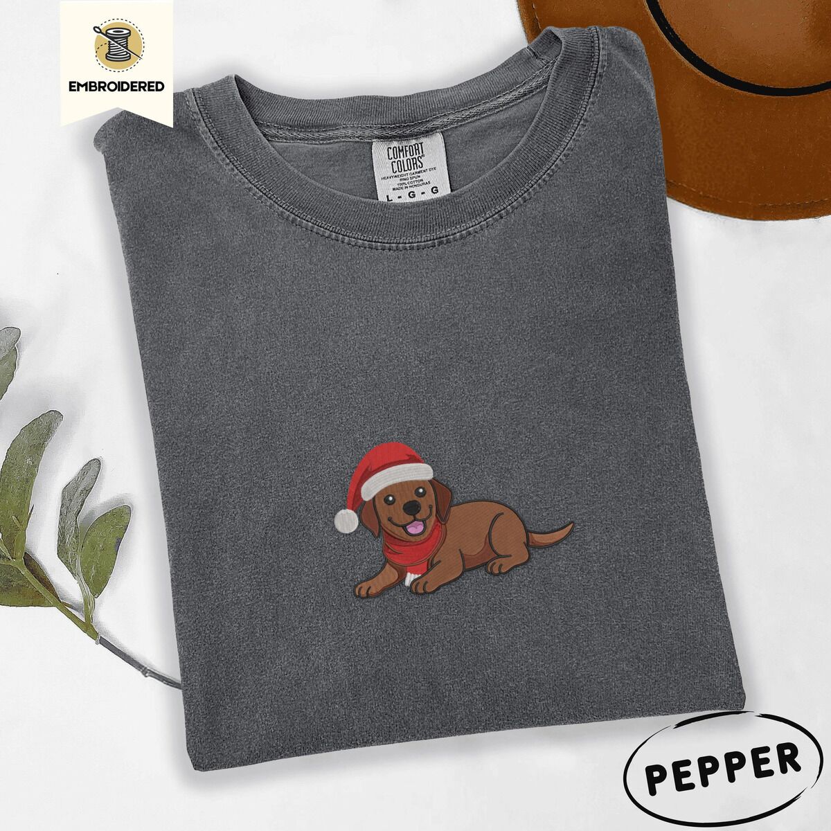 Chocolate Lab Santa Hat Shirt – Pepper Pepper Comfort Colors T-shirt embroidered with a chocolate Labrador puppy lying down in a red Santa hat and a red knit scarf