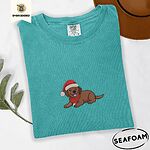 Seafoam Comfort Colors T-shirt embroidered with a chocolate Labrador puppy lying down in a red Santa hat and a red knit scarf