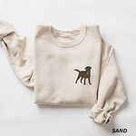 Sand crewneck sweatshirt laid flat on white, embroidered with a small chocolate brown Labrador silhouette in a blue collar and gold bone tag on the left chest