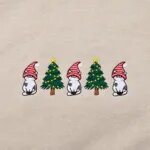 Close-up of the embroidered cats in red-and-white gnome hats between two Christmas trees with yellow lights and stars