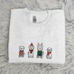 Folded Christmas dog crewneck with a row of four embroidered holiday dogs across the chest