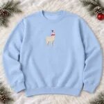Light blue Christmas llama crewneck laid flat with the small embroidered llama centered on the chest, pine sprigs and pine cones