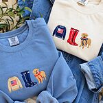 Blue Jean and Ivory Comfort Colors sweatshirts on a denim jacket, one with a tan flag sweater, navy boots and a golden in a red bow, the other with a navy sweater, red boots and a navy bow