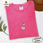 Crunchberry Comfort Colors T-shirt embroidered with a cream goose in a Santa hat with a red ribbon bow at its neck