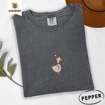 Pepper Comfort Colors T-shirt embroidered with a cream goose in a Santa hat with a red ribbon bow at its neck