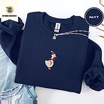 Navy crewneck sweatshirt folded with ripped jeans and a silver chain necklace, embroidered with a white goose in a Santa hat and a red ribbon bow in the center of the chest