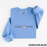Carolina Blue crewneck sweatshirt laid flat on white, embroidered with CORGI MOM and a fluffy corgi butt with pointed ears