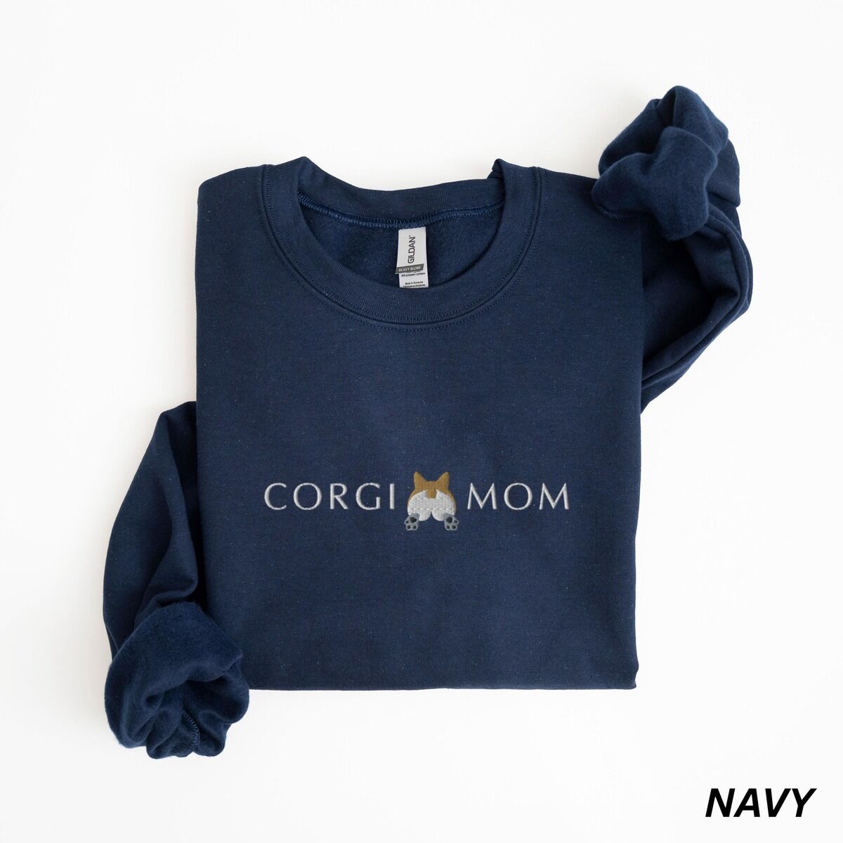 Corgi Butt Sweatshirt – Navy Navy crewneck sweatshirt laid flat on white, embroidered with CORGI MOM and a fluffy corgi butt with pointed ears