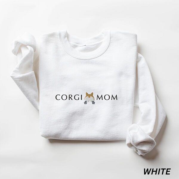 White crewneck sweatshirt laid flat on white, embroidered with CORGI MOM in dark thread and a fluffy corgi butt between the words
