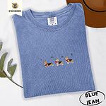 Blue Jean Comfort Colors T-shirt embroidered with three tricolor corgis in red knit scarves among sprigs of holly