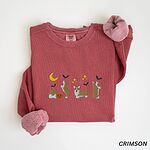 Crimson crewneck sweatshirt laid flat with rolled sleeves, embroidered with four corgis under a crescent moon with bats, gold sparkles and a jack-o'-lantern