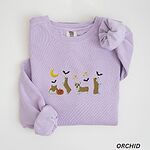 Orchid crewneck sweatshirt laid flat with a rolled sleeve, embroidered with four corgis under a crescent moon with bats, gold sparkles and a jack-o'-lantern
