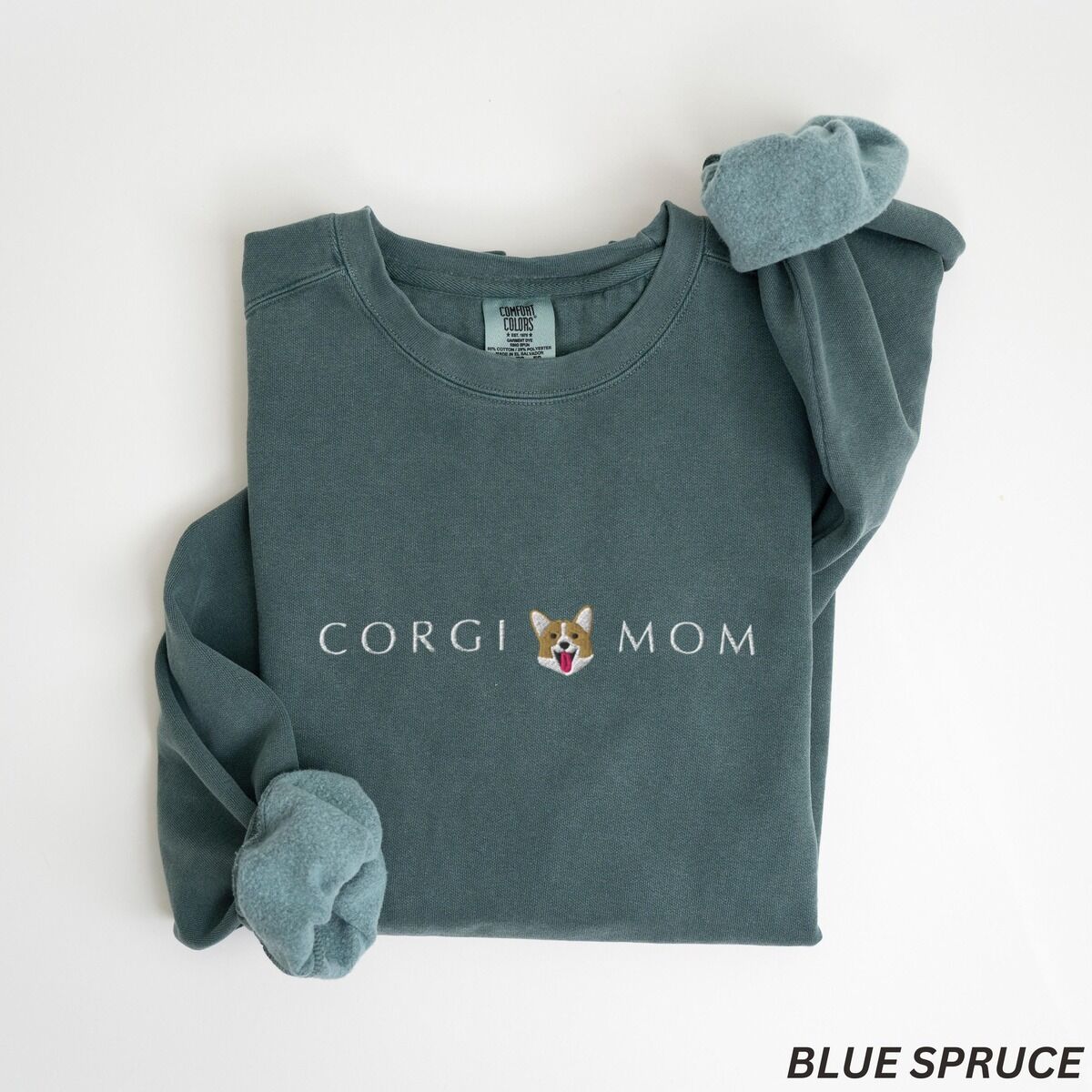 Corgi Mom Sweatshirt – Blue Spruce Blue Spruce crewneck sweatshirt laid flat on white, embroidered with CORGI MOM in light thread and a red and white corgi face