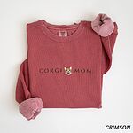 Crimson crewneck sweatshirt laid flat on white, embroidered with CORGI MOM and a small red and white corgi face