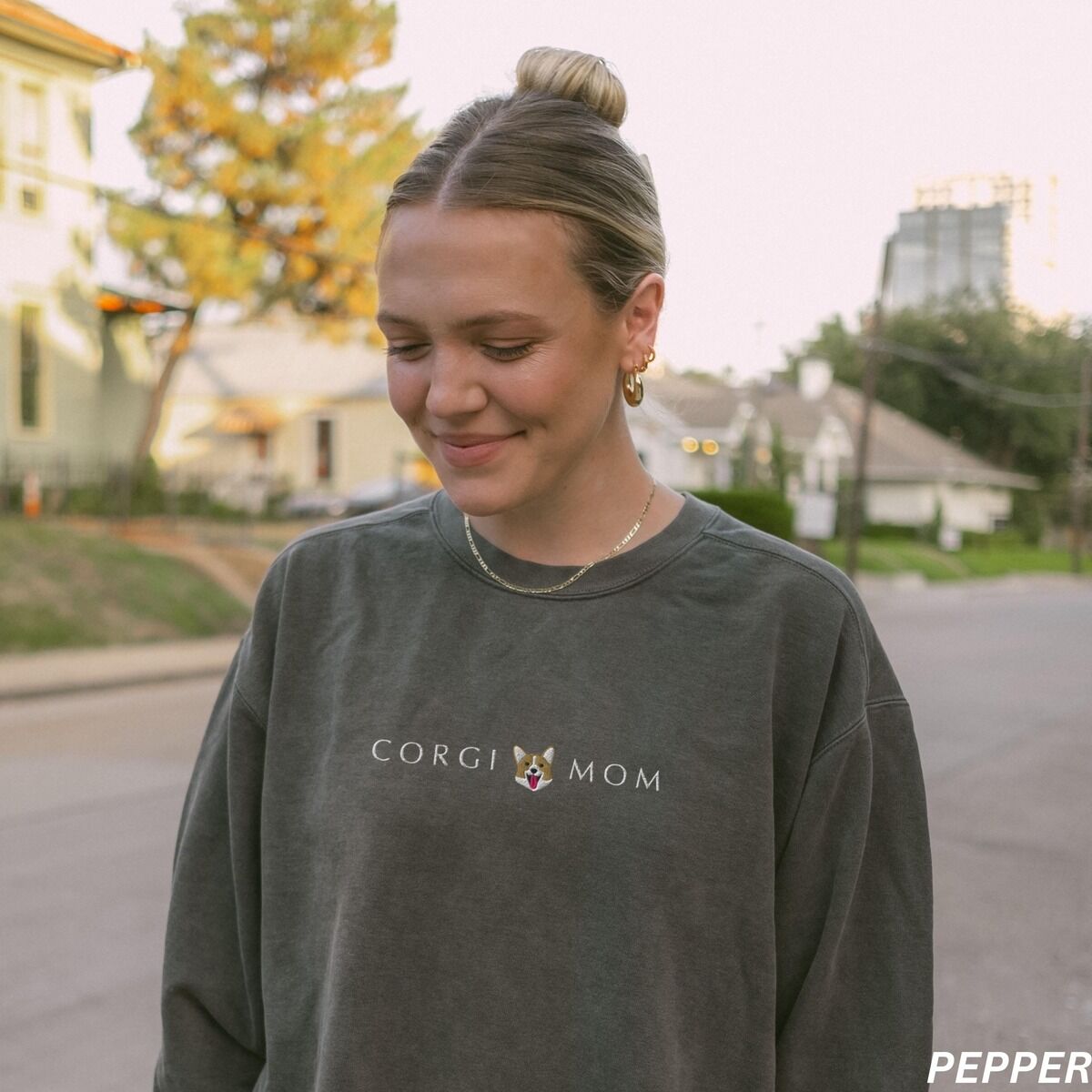 Corgi Mom Sweatshirt – Pepper Woman on a city street in a Pepper crewneck sweatshirt embroidered with CORGI MOM and a little corgi face