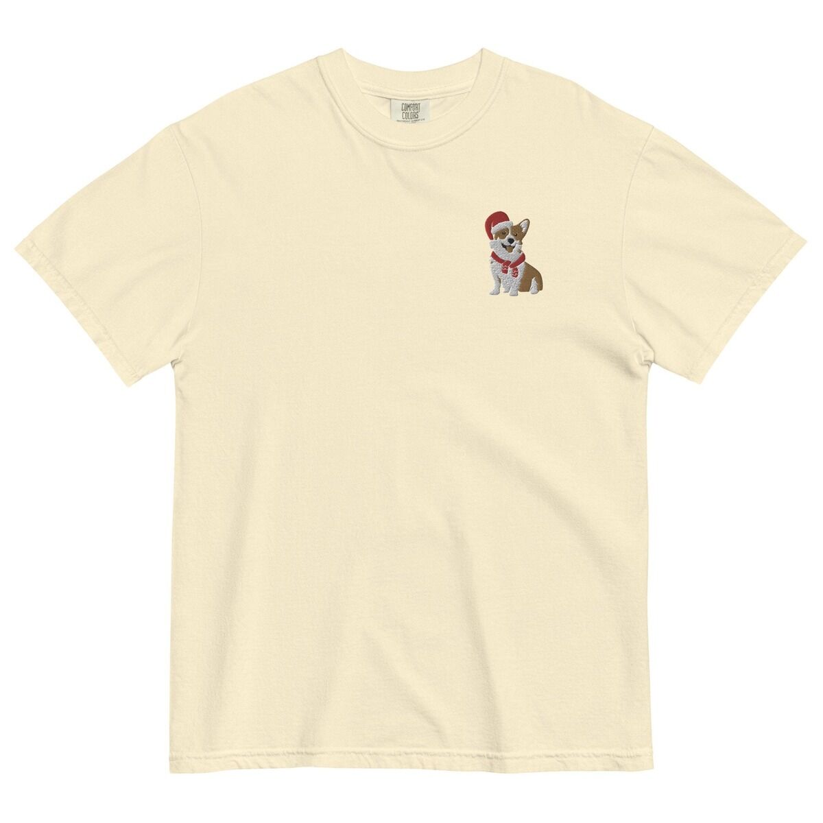 Corgi Santa Hat Shirt – Ivory Ivory T-shirt laid flat on a white background, embroidered with a smiling red and white Pembroke corgi in a Santa hat and striped red scarf on the left chest