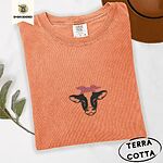 Terracotta Comfort Colors T-shirt embroidered with a black and white cow head wearing a pink heart bandana tied in a bow