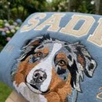 Close-up of the embroidered Australian Shepherd portrait and beige varsity letters on the custom dog crewneck