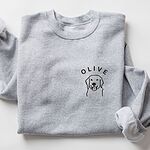 Sport Grey crewneck sweatshirt laid flat, embroidered with a line art golden retriever face and the name OLIVE on the left chest
